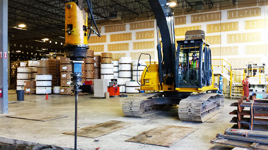 Inside the warehouse, a pipe pile is driven for a deep foundation